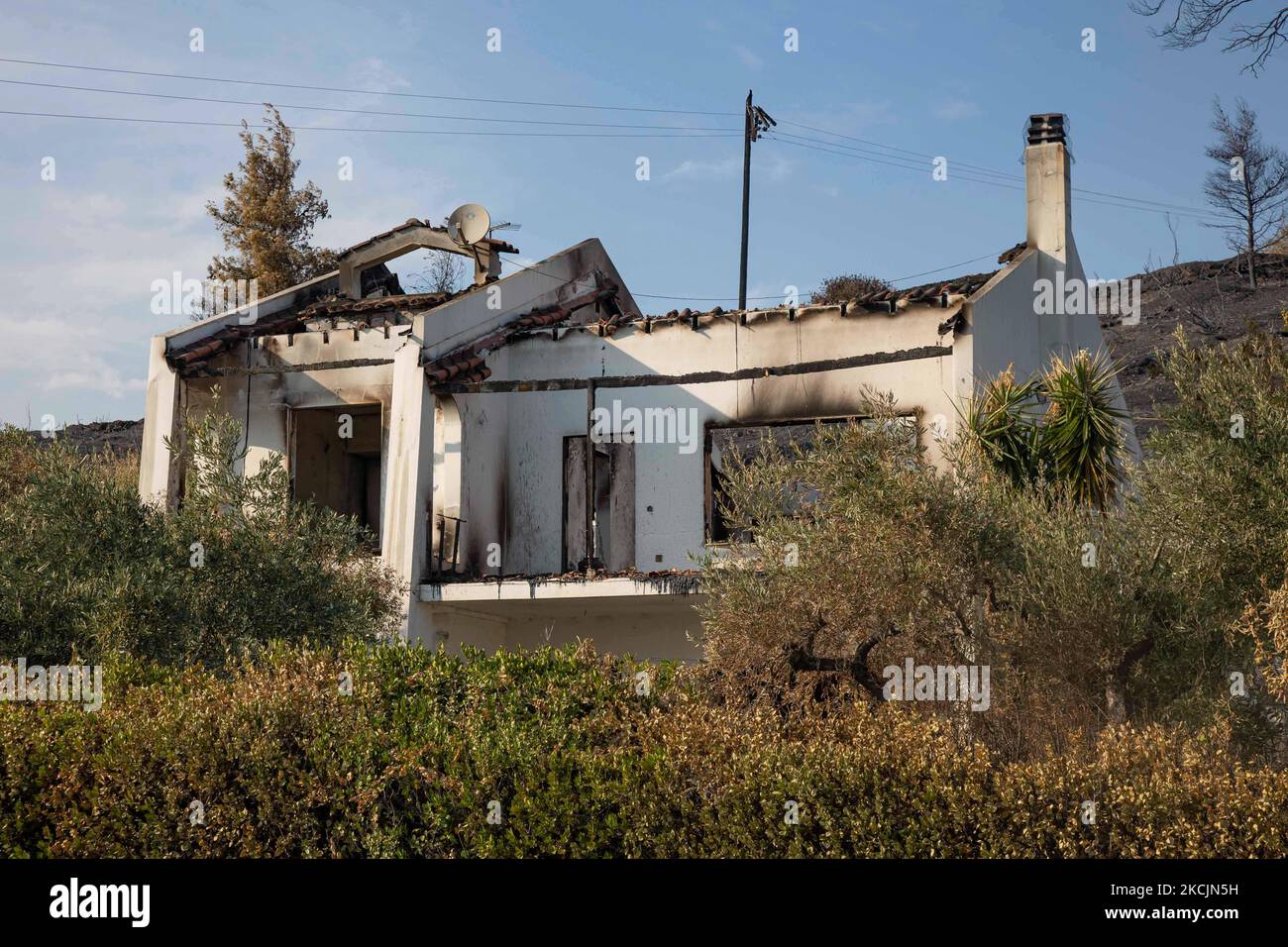 Una casa quemada en el pueblo de Rovies. Las secuelas de los incendios en  Grecia, mientras que todavía se queman pequeñas llamas en el bosque. En  Grecia se produjo un enorme desastre