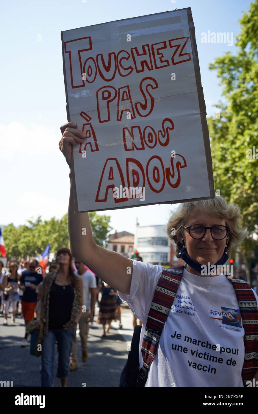 Un manifestante muestra un cartón 'No toque a nuestros adolescentes'. Varios miles de manifestantes salieron a las calles en Toulouse contra la vacunación casi obligatoria y contra el pase de salud obligatorio después del discurso de Macron el 12th de julio. El 12th de julio, Macron anunció que el pase de salud será obligatorio para entrar a una amplia variedad de lugares públicos como cafés, teatros, salas de conciertos, cines, centros comerciales, Transporte público, piscinas e incluso hospitales a menos que se produzca una situación crítica, etc. La prohibición de espacios públicos para personas no vacunadas ha comenzado el 9th de agosto. El Preset tiene una vez Foto de stock