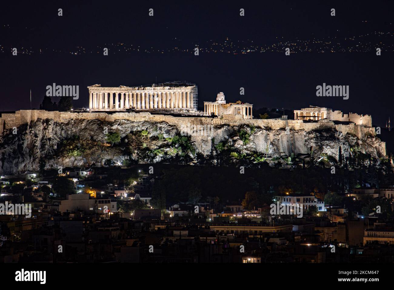 Vista nocturna del Partenón y la Acrópolis con un ferry que pasa al fondo  en la capital griega Athina. La técnica de la fotografía de la exposición  larga está demostrando las antigüedades