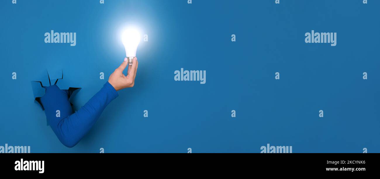 lámpara de mano sobre fondo azul, diseño panorámico Foto de stock