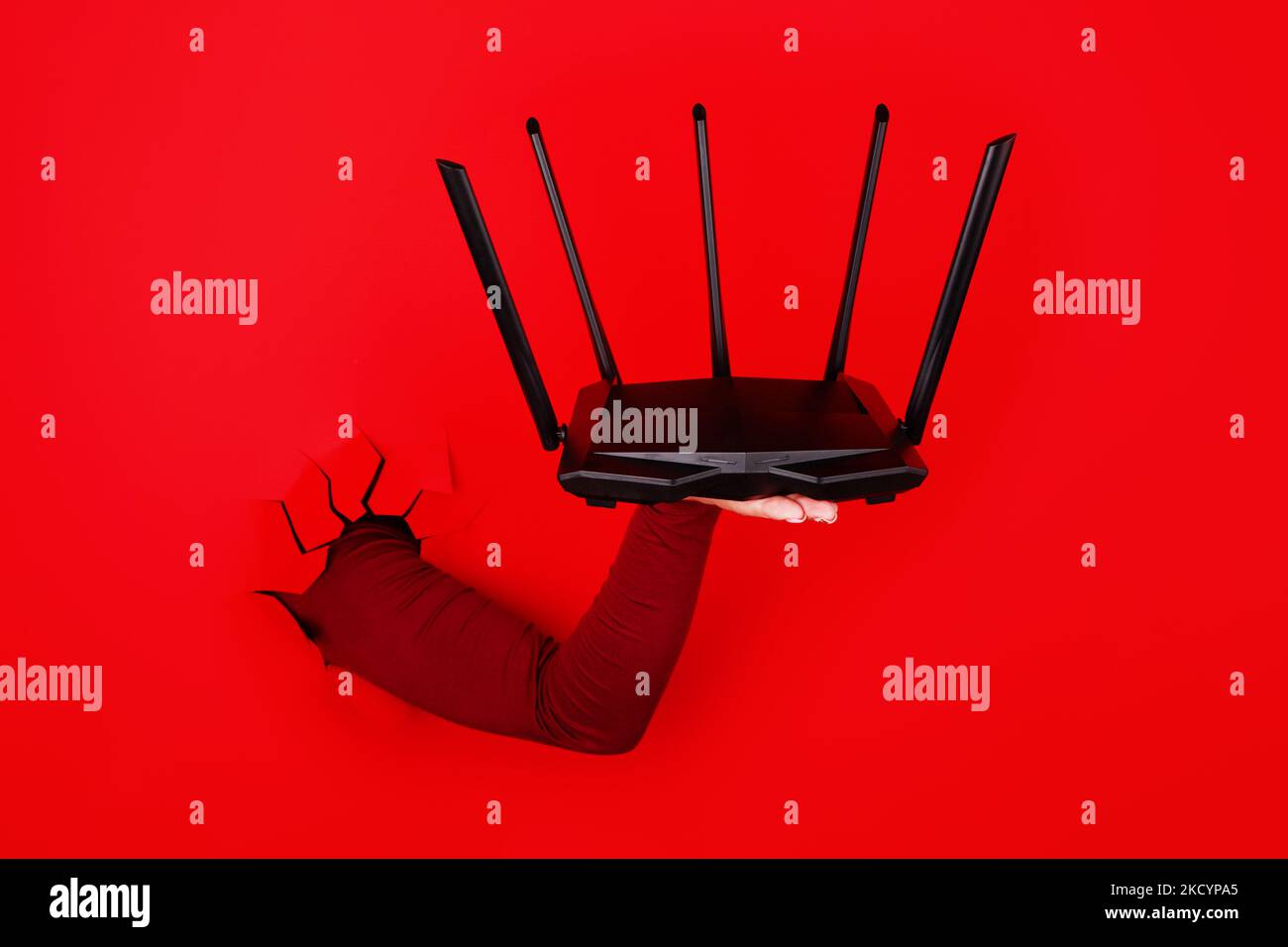 router wifi negro sobre fondo rojo Foto de stock