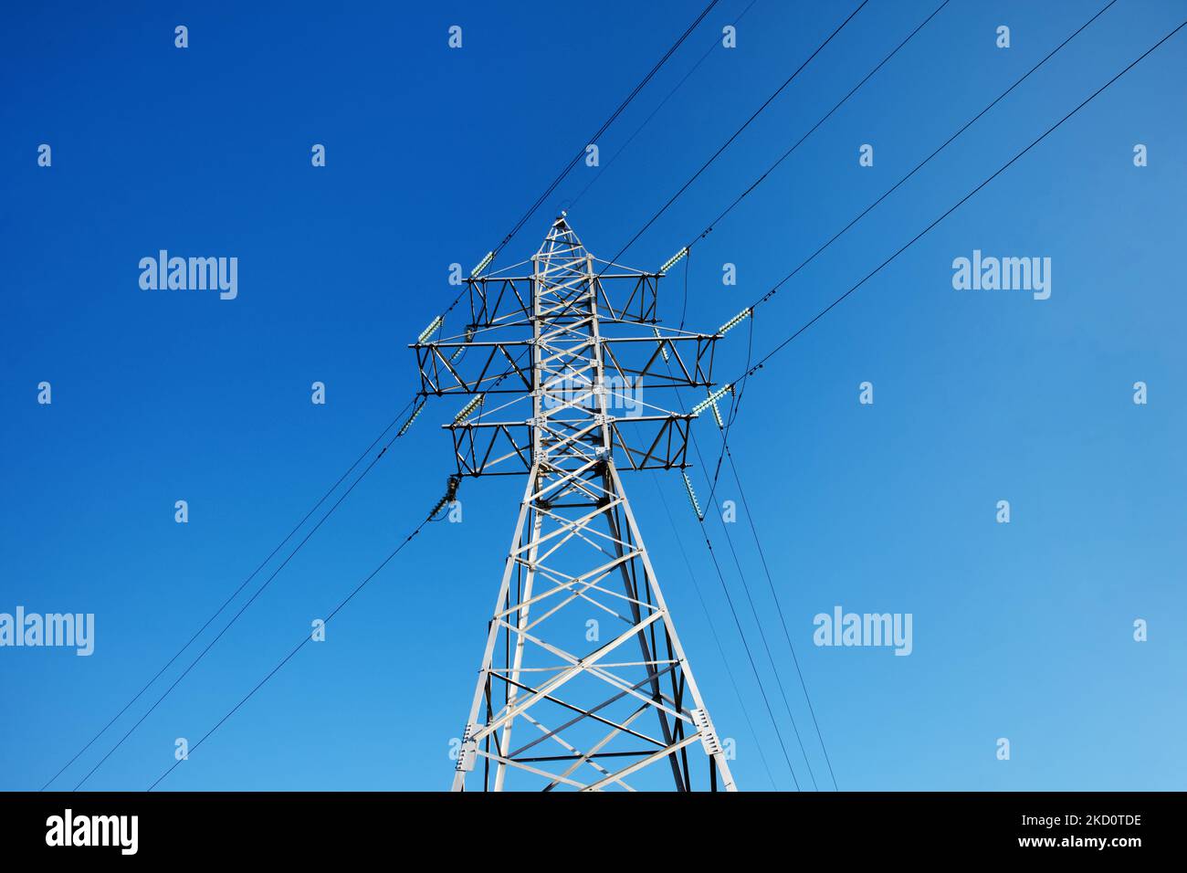 Polo eléctrico sobre cielo azul, torre de alta tensión Foto de stock