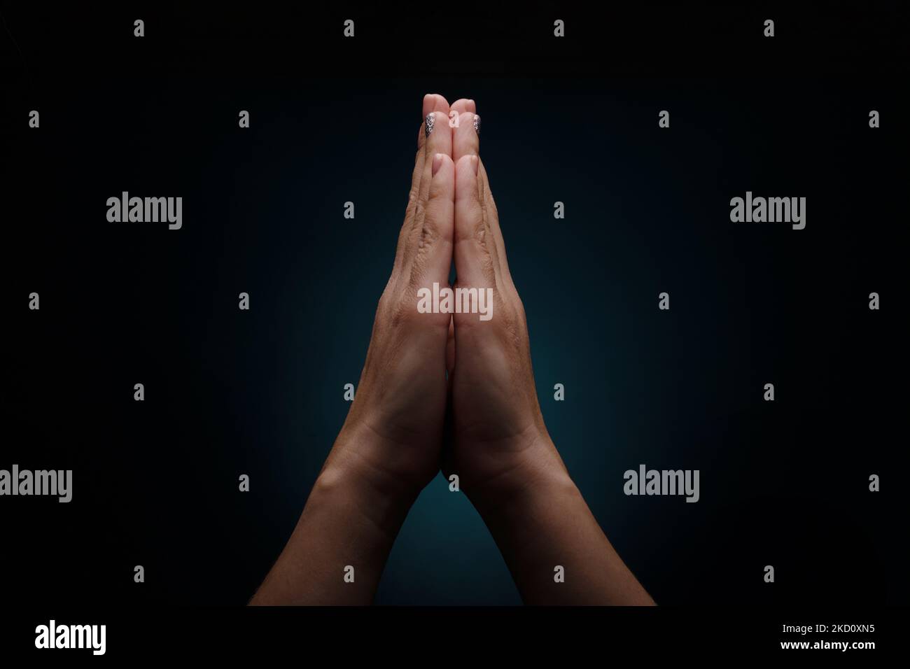 oración de manos sobre fondo oscuro, gesto namaste Foto de stock