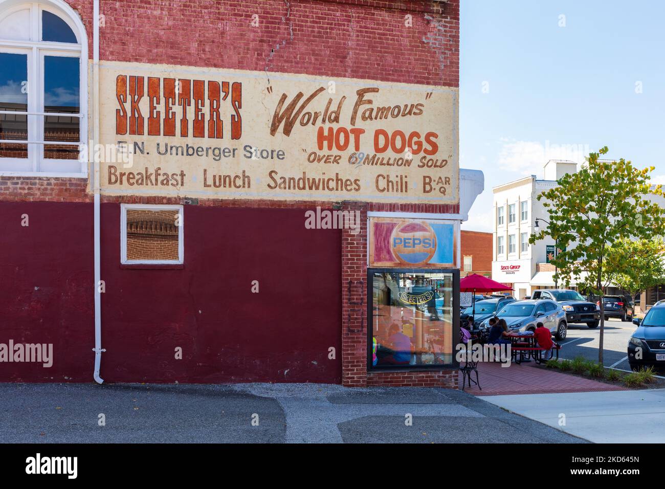WYTHEVILLE, VA, EE.UU.-15 DE OCTUBRE de 2022: El restaurante Skeeter muestra un cartel pintado en la pared y asientos exteriores en la acera. Los clientes cenan fuera. Foto de stock