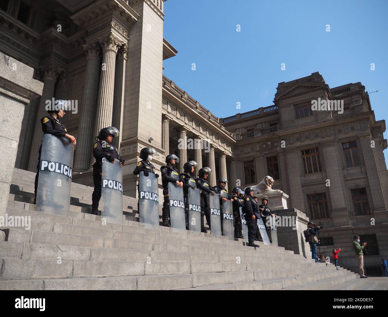 Escuadrón de la policía protegiendo el palacio de justicia cuando miles de personas toman las calles, una vez más, para protestar contra el presidente Pedro Castillo. Castillo, quien está inmerso en varias investigaciones por presuntos actos de corrupción en los que también estaría involucrado su séquito más cercano, ha solicitado la intervención de la OEA para apoyar a su régimen. Foto de stock