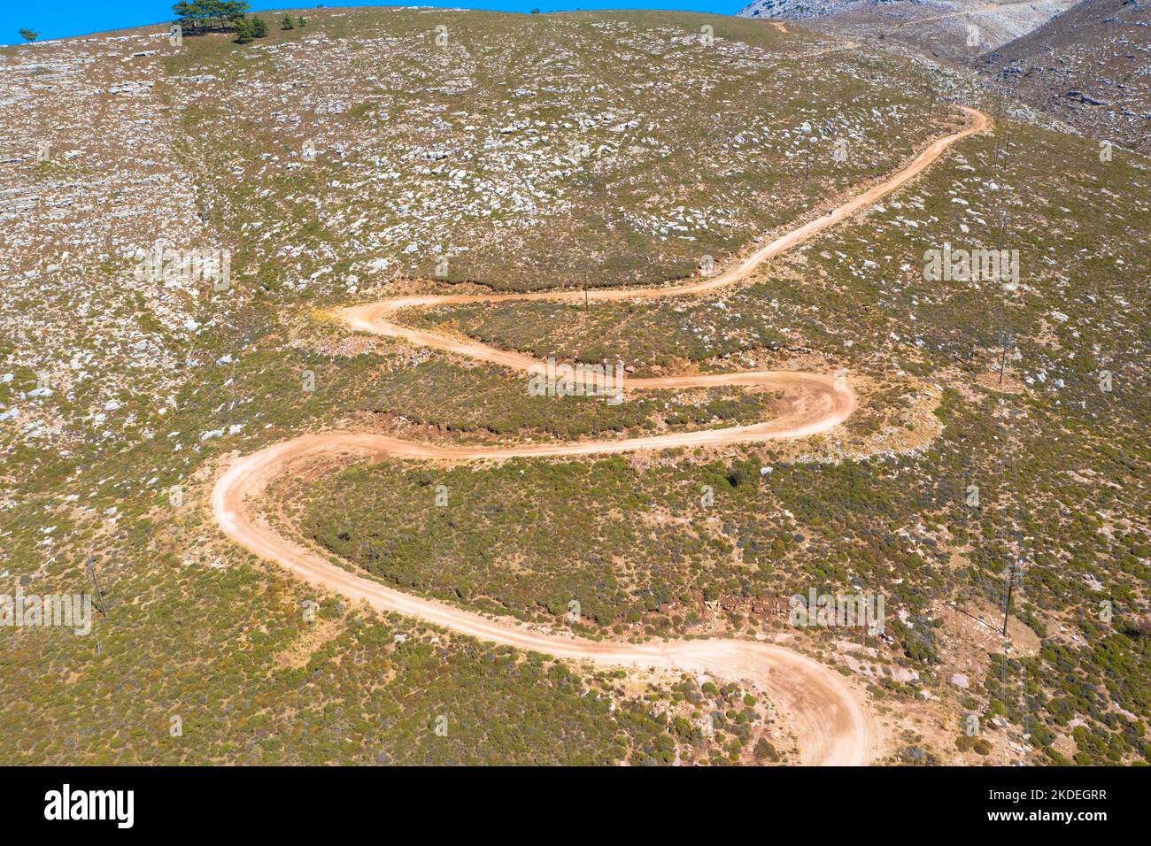 Espectacular vista aérea con pista serpentina fuera de carretera hasta la cima de la montaña Attavyros. La montaña más alta de la isla de Rodas, Grecia. Foto de stock