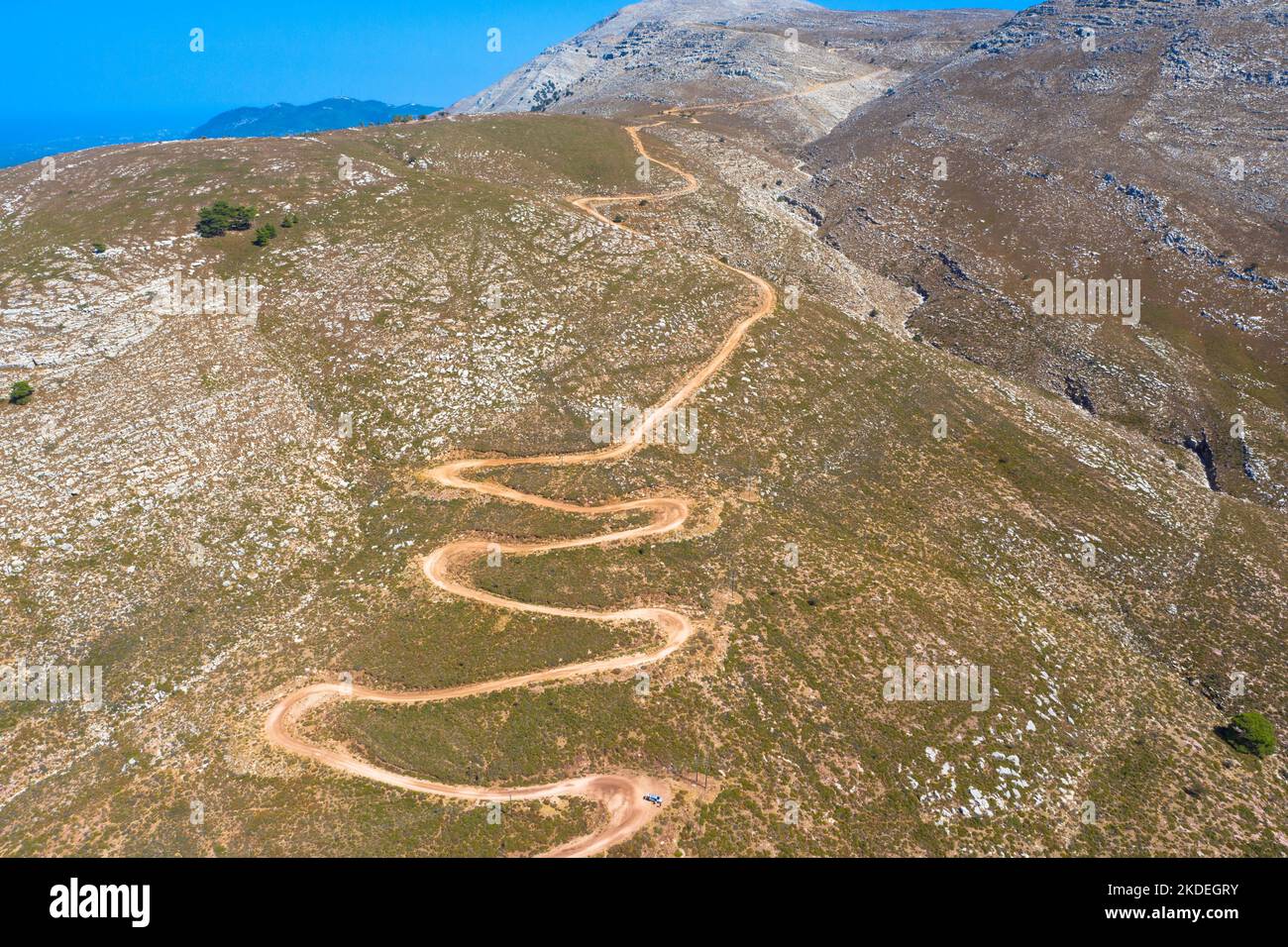 Espectacular vista aérea con pista serpentina fuera de carretera hasta la cima de la montaña Attavyros. La montaña más alta de la isla de Rodas, Grecia. Foto de stock