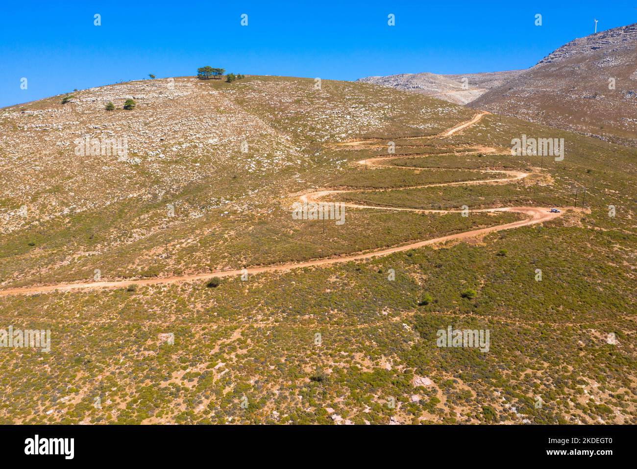 Espectacular vista aérea con pista serpentina fuera de carretera hasta la cima de la montaña Attavyros. La montaña más alta de la isla de Rodas, Grecia. Foto de stock