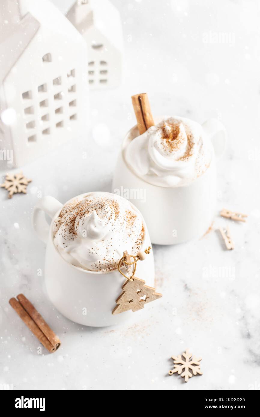 https://c8.alamy.com/compes/2kdgdg5/dos-tazas-de-chocolate-caliente-o-cacao-con-crema-batida-y-canela-sobre-fondo-de-marmol-blanco-con-luces-bokeh-maqueta-navidena-tarjeta-con-espacio-de-texto-2kdgdg5.jpg