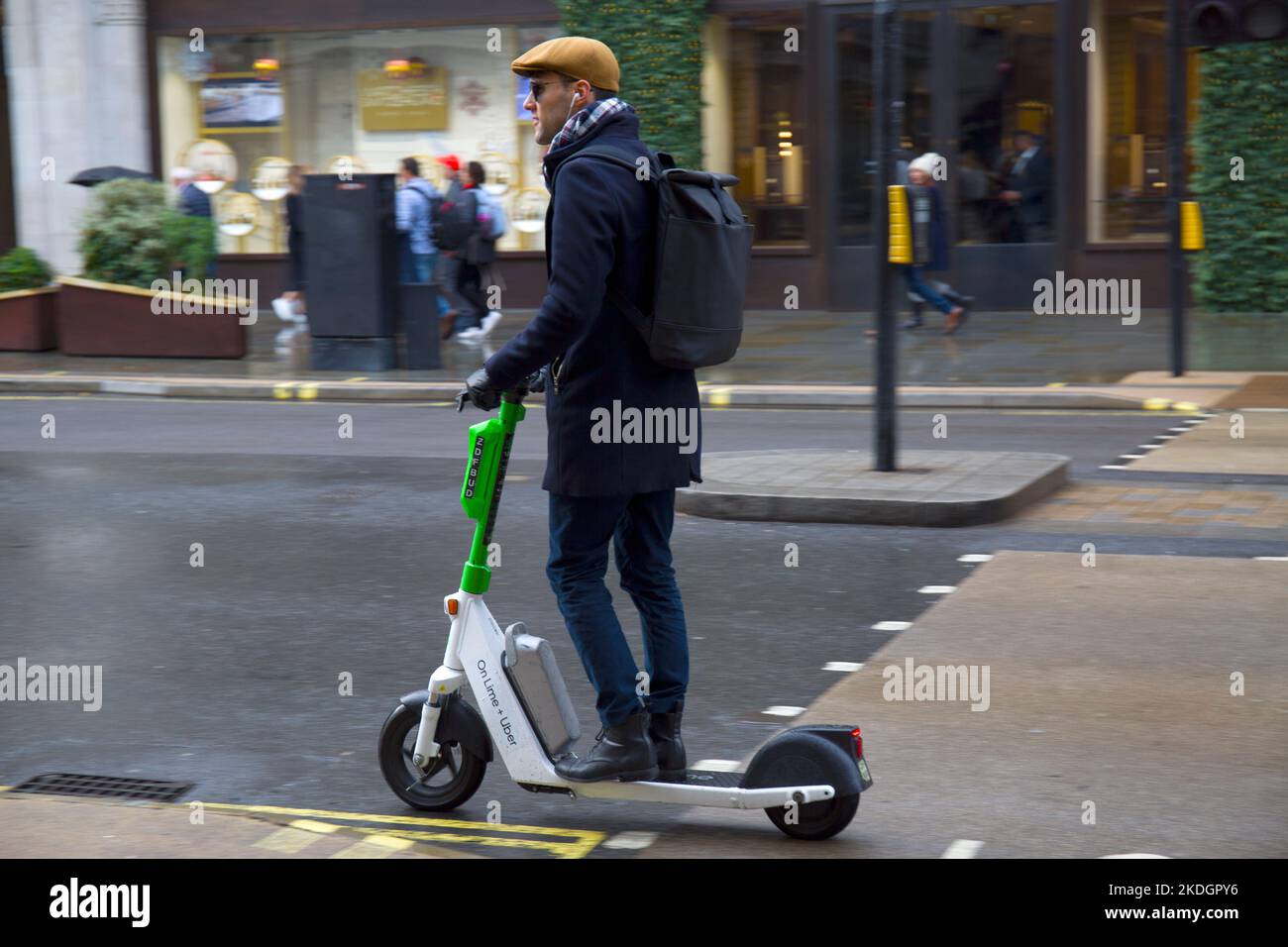 Joven inteligente montando en Lime + Uber Electric Scooter en Regent Street Westminster London West End Foto de stock