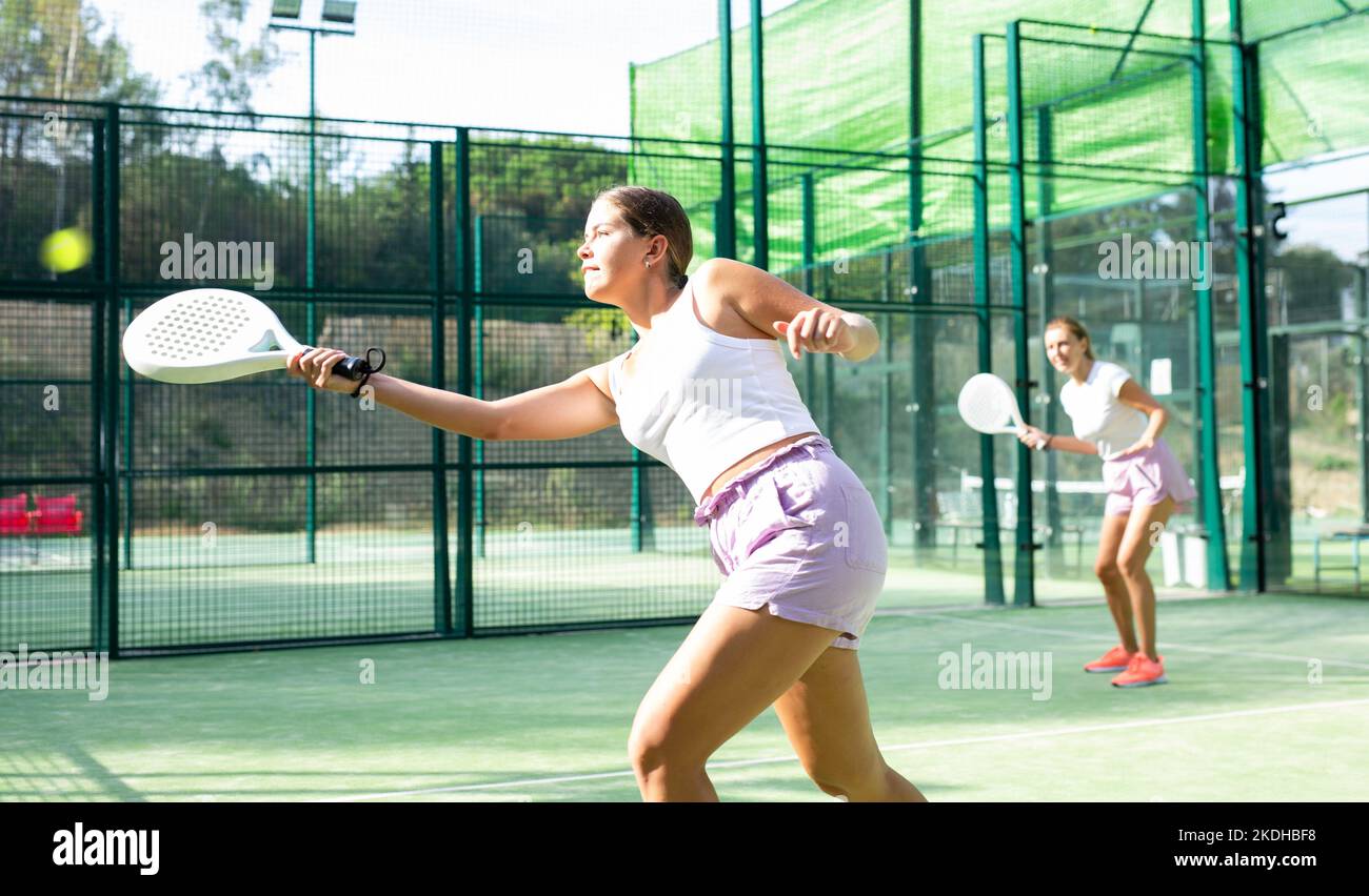 Mujer en pantalones cortos jugando tenis de pádel en la cancha Fotografía  de stock - Alamy