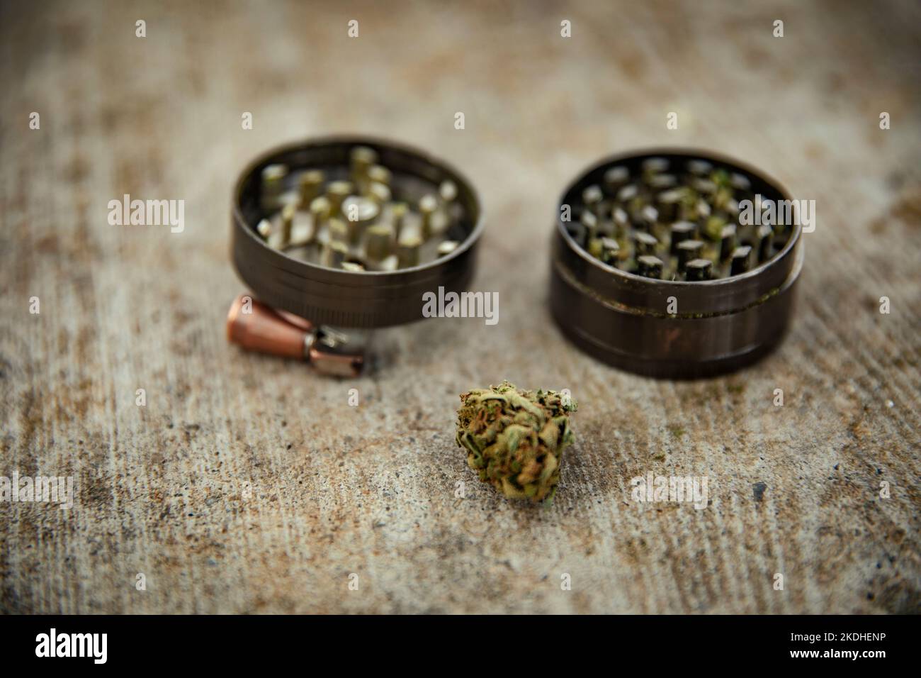 Muela junto a un brote de marihuana sobre una superficie de madera Foto de stock