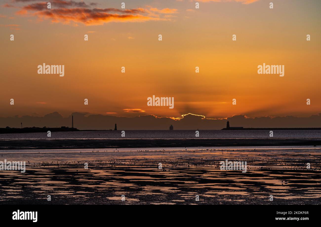 Los rayos crepusculares sobre el mar de Irlanda cuando el sol sale detrás de una pared de nubes. Foto de stock
