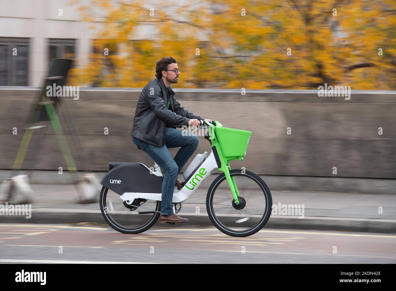 Un hombre montando una bicicleta eléctrica de alquiler Lime en Waterloo Bridge, Londres, Reino Unido. 16 de octubre de 2022 Foto de stock