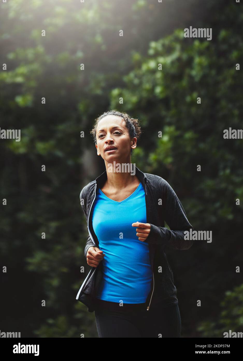 Quemará más calorías intercambiando la cinta de correr por senderos. Una mujer deportiva para correr. Foto de stock