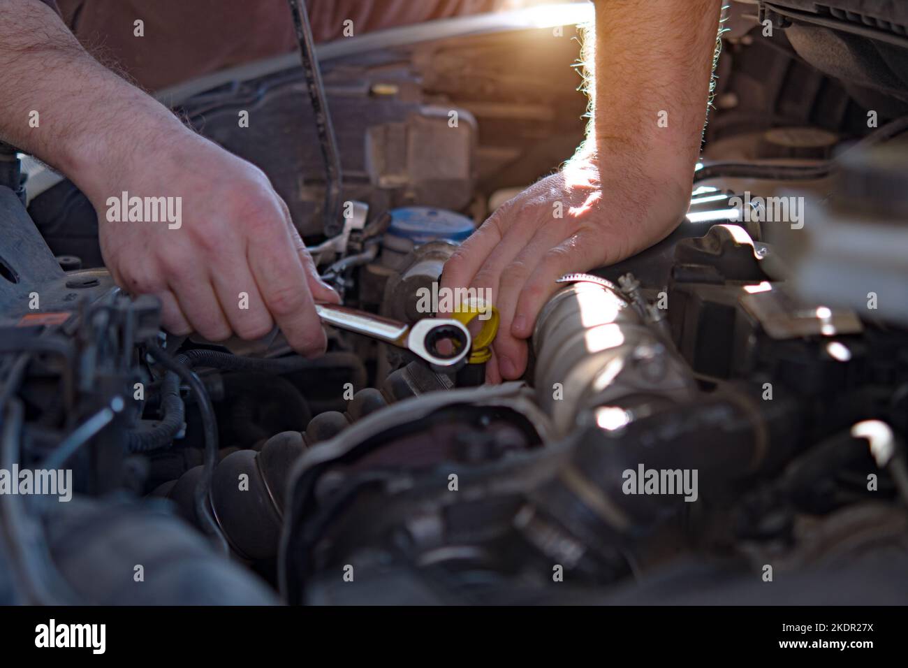 Mecánico de automóviles trabajando en el motor de coches en el garaje de mecánicos. Servicio de reparación. Primer plano auténtico Foto de stock