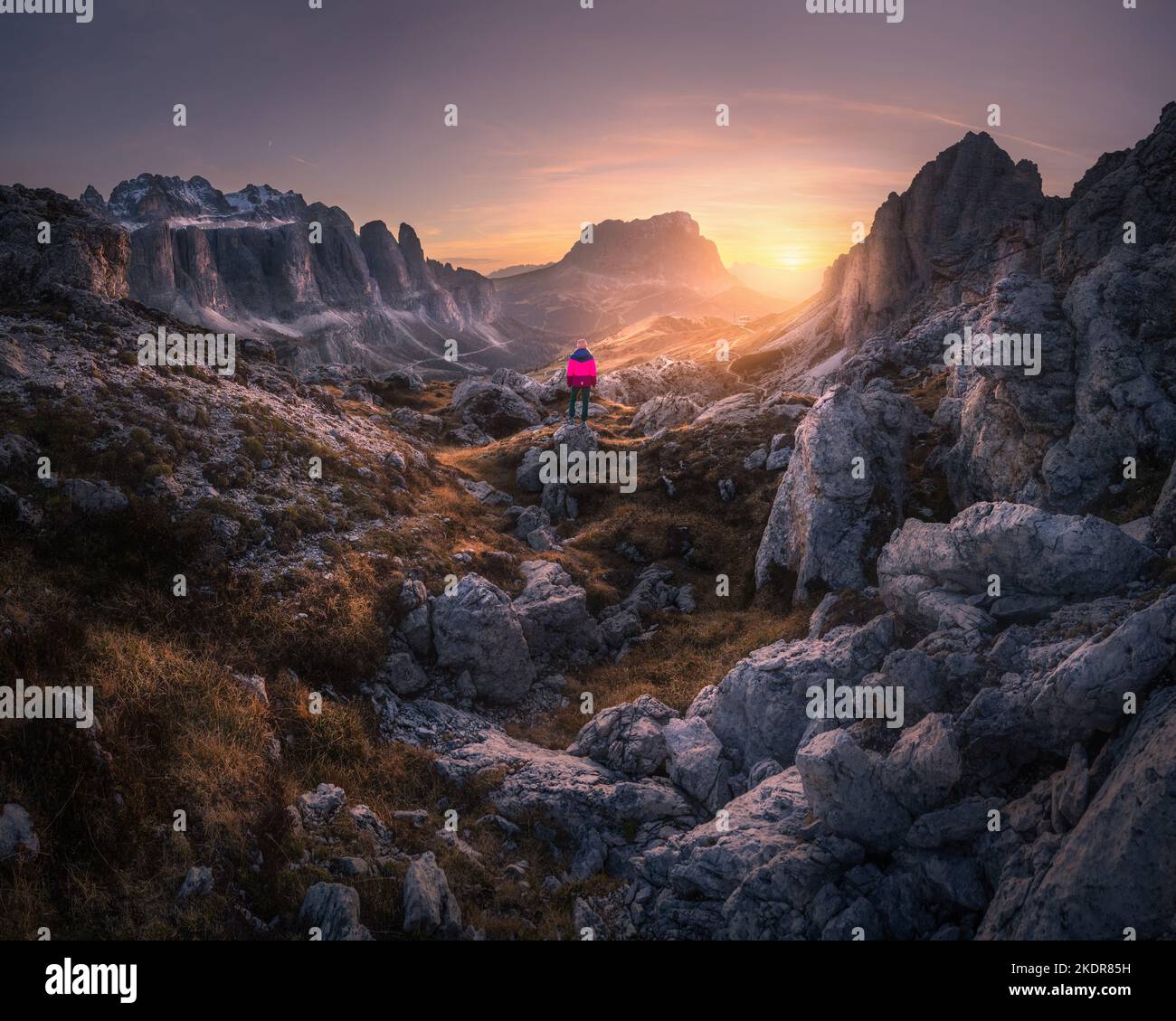Mujer en el sendero de montaña y piedras al atardecer en otoño Foto de stock