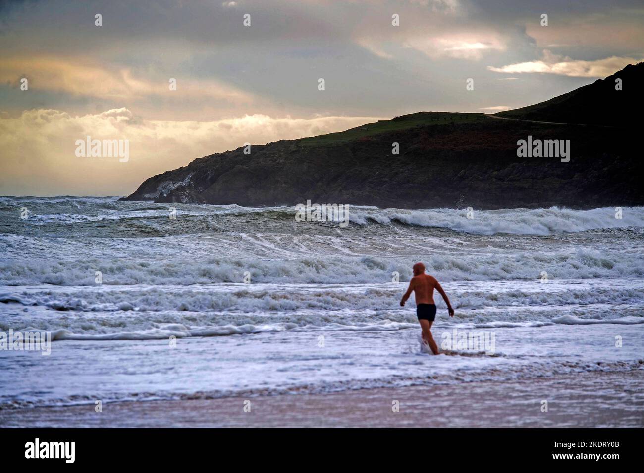 Swansea, Reino Unido. 08th de Nov de 2022. Un nadador brave las condiciones tormentosas en la bahía de Langland, cerca de Swansea, esta tarde durante un descanso en la fuerte lluvia que ha estado golpeando la costa de Gales del Sur. Crédito: Phil Rees/Alamy Live News Foto de stock