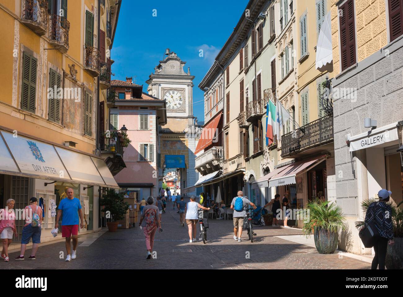 Pelo Italia, vista en verano de la gente caminando por las tiendas de lujo que bordean cada lado de la Via San Carlo en la pintoresca ciudad del Lago Garda de Salo, Italia Foto de stock