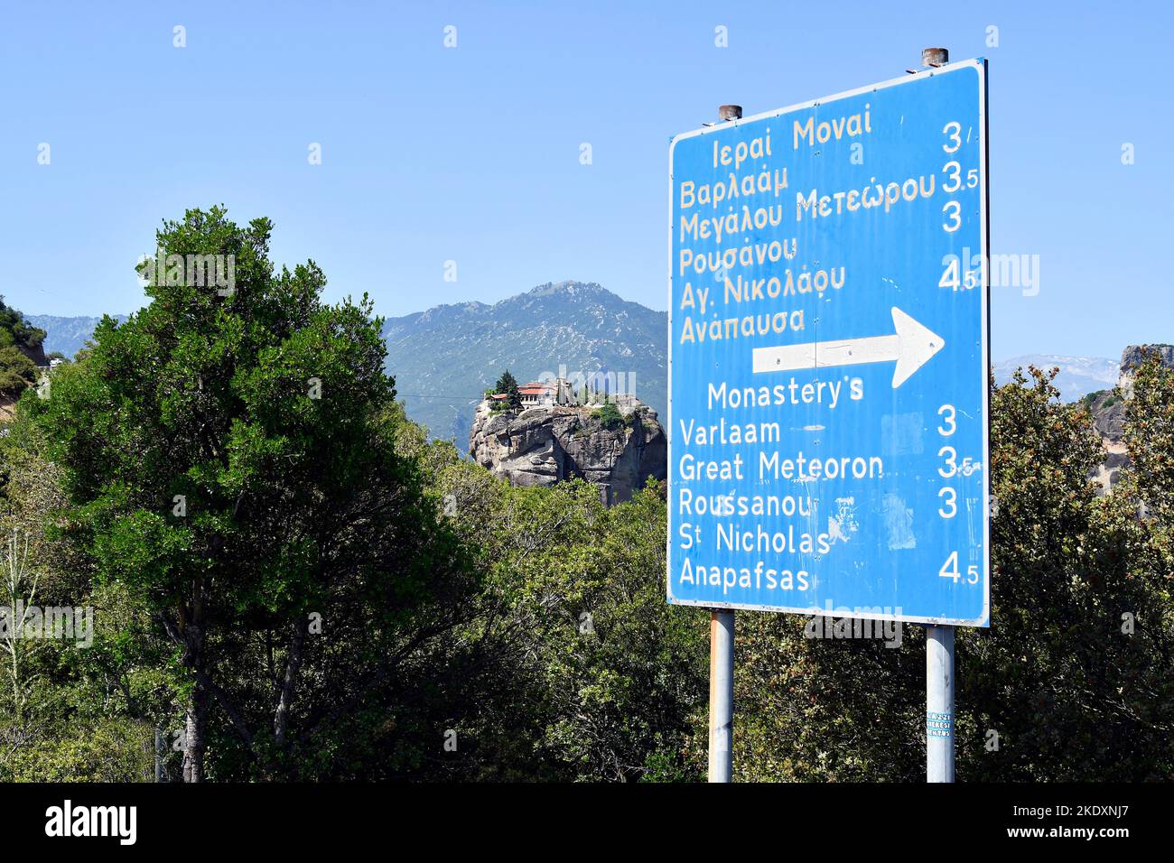 Grecia, signo de dirección a diferentes monasterios y monasterio Agia Triada aka Santísima Trinidad, uno de los monasterios de Meteora en el fondo, un WOR UNESCO Foto de stock