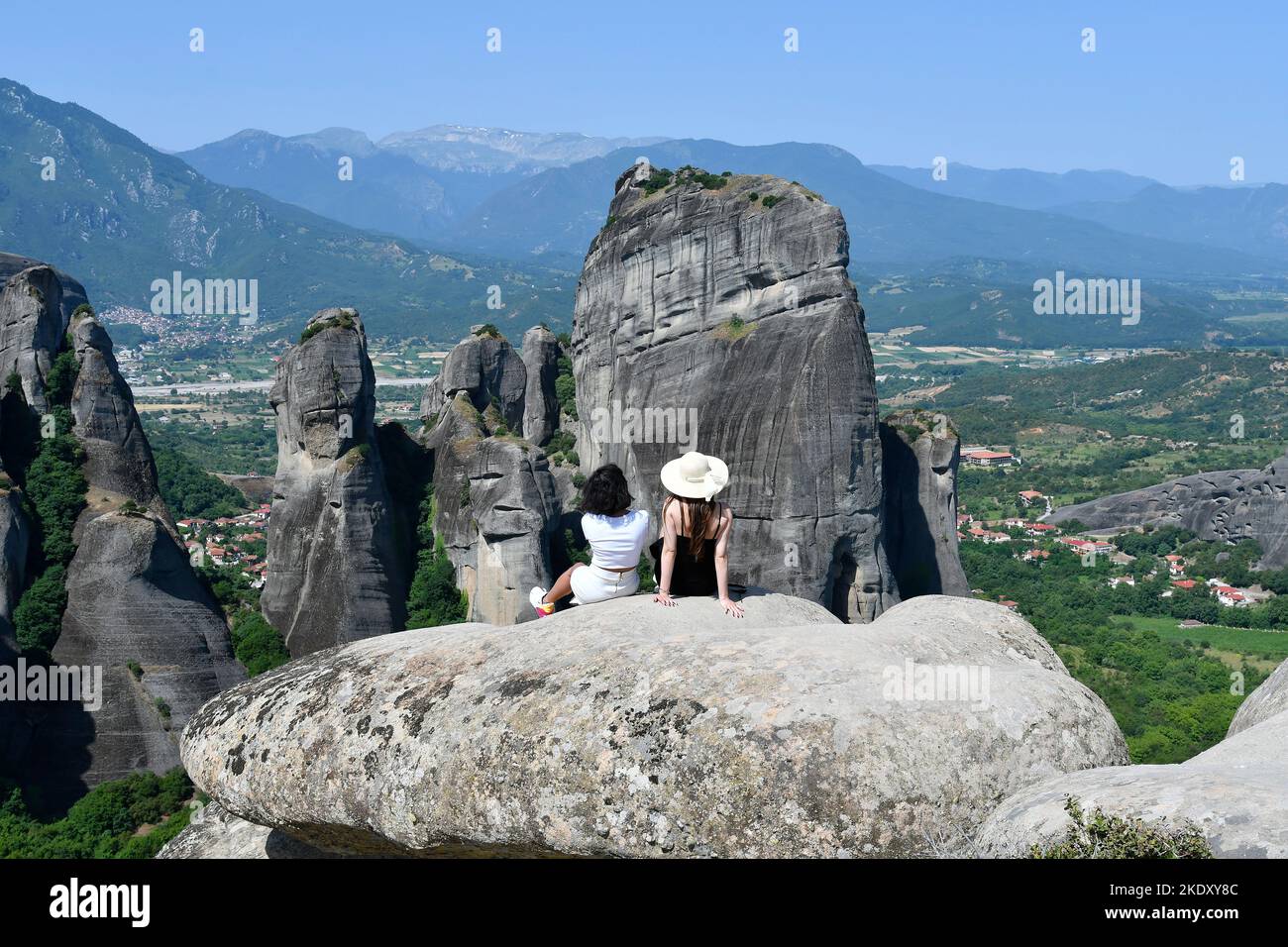 Grecia, dos mujeres no identificadas disfrutan de una vista sobre el gran paisaje de las rocas de Meteora en el lugar declarado Patrimonio de la Humanidad por la UNESCO en Tesalia Foto de stock