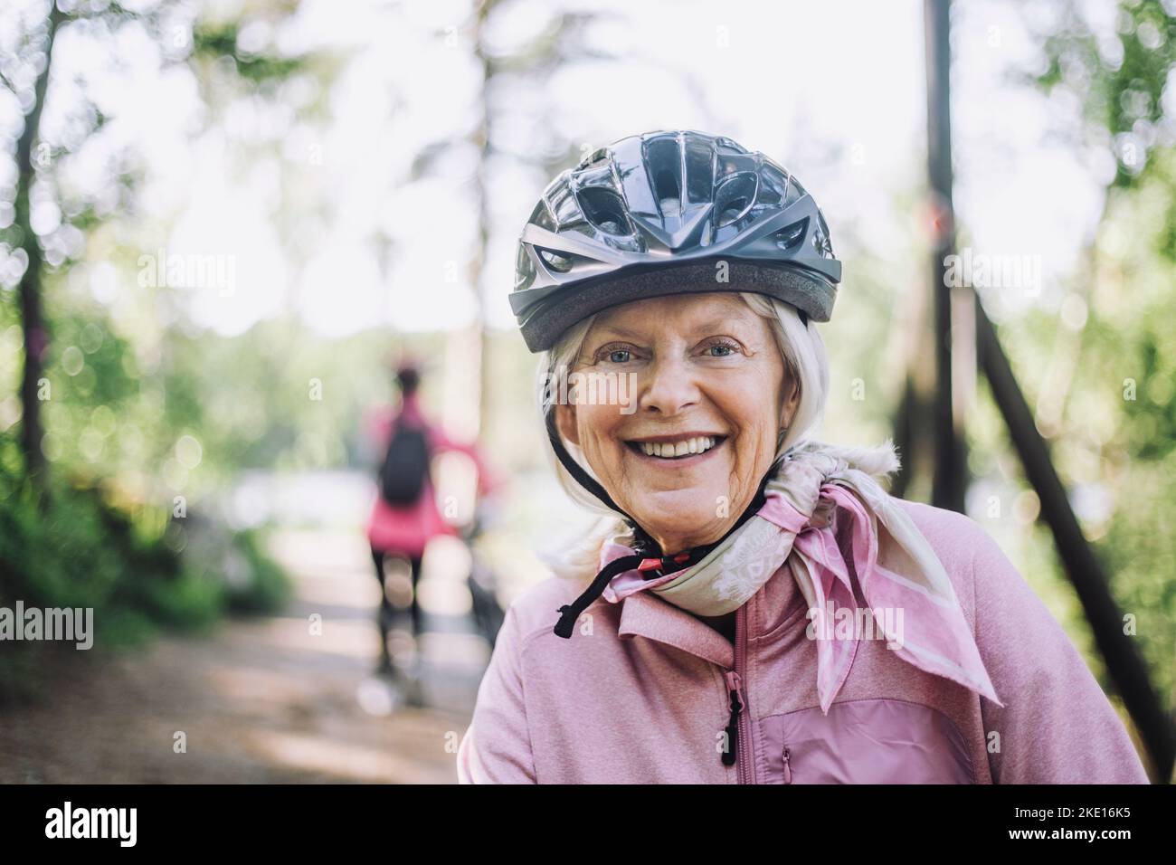 Retrato de una feliz mujer mayor con casco de ciclismo Foto de stock