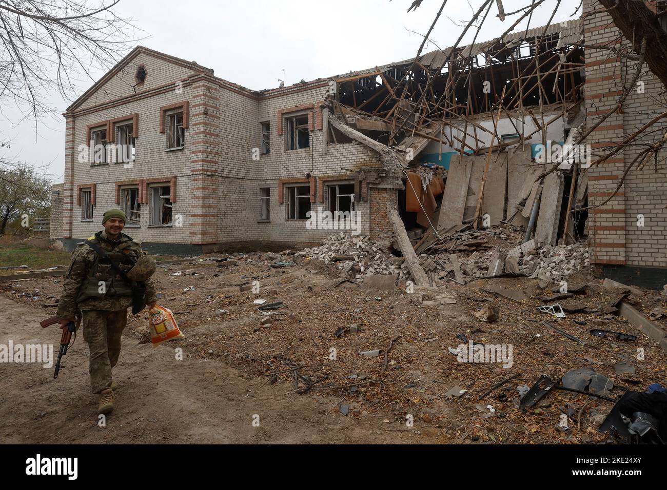 Un militar ucraniano camina por un edificio de una guardería dañada durante un ataque con misiles rusos en la aldea de Novooleksandrivka, en la región de Kherson, Ucrania, el 9 de noviembre de 2022. REUTERS/Valentyn Ogirenko Foto de stock