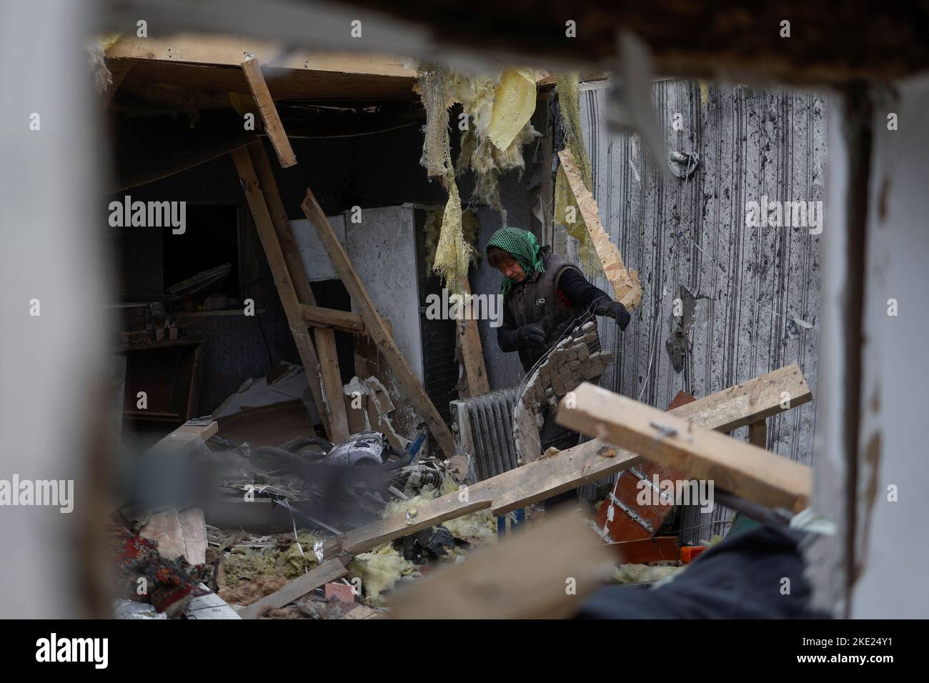 La residente local Serhii Tamara remueve escombros dentro de una casa de su hijo, destruida durante un ataque militar ruso en la aldea de Novooleksandrivka, en la región de Kherson, Ucrania, 9 de noviembre de 2022. REUTERS/Valentyn Ogirenko Foto de stock