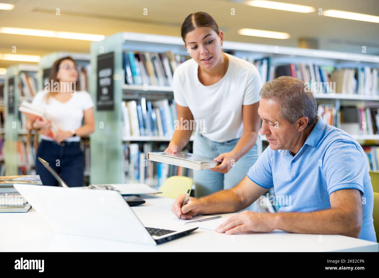 Joven mujer tutor americana que enseña a un anciano caucásico maduro Foto de stock