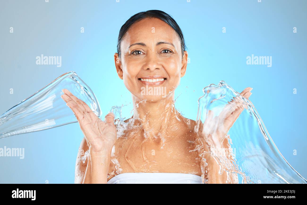 Agua salpicada, mujer y retrato de belleza sobre fondo azul, cuidado de la piel o bienestar facial, cuidado corporal y ducha, limpieza e higiene personal. Maduro Foto de stock