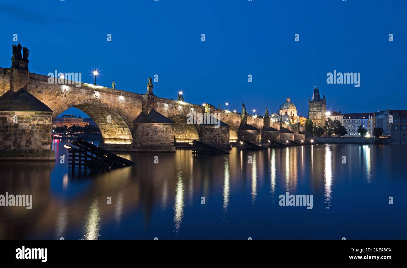 Puente Charles iluminado por la noche en Praga República Checa Foto de stock