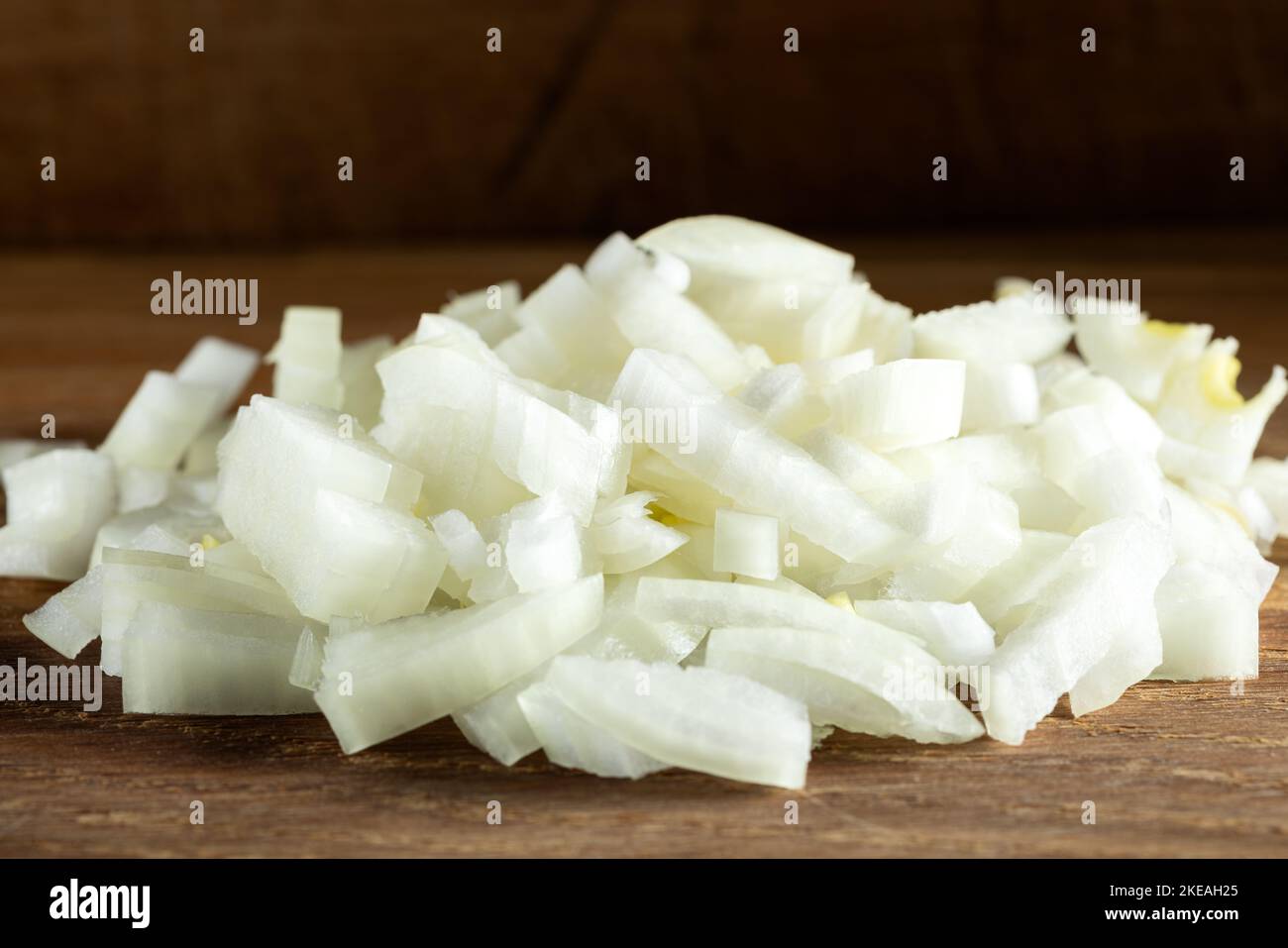 Cebolla blanca picada fresca en una tabla de cortar de madera - vista de primer plano Foto de stock