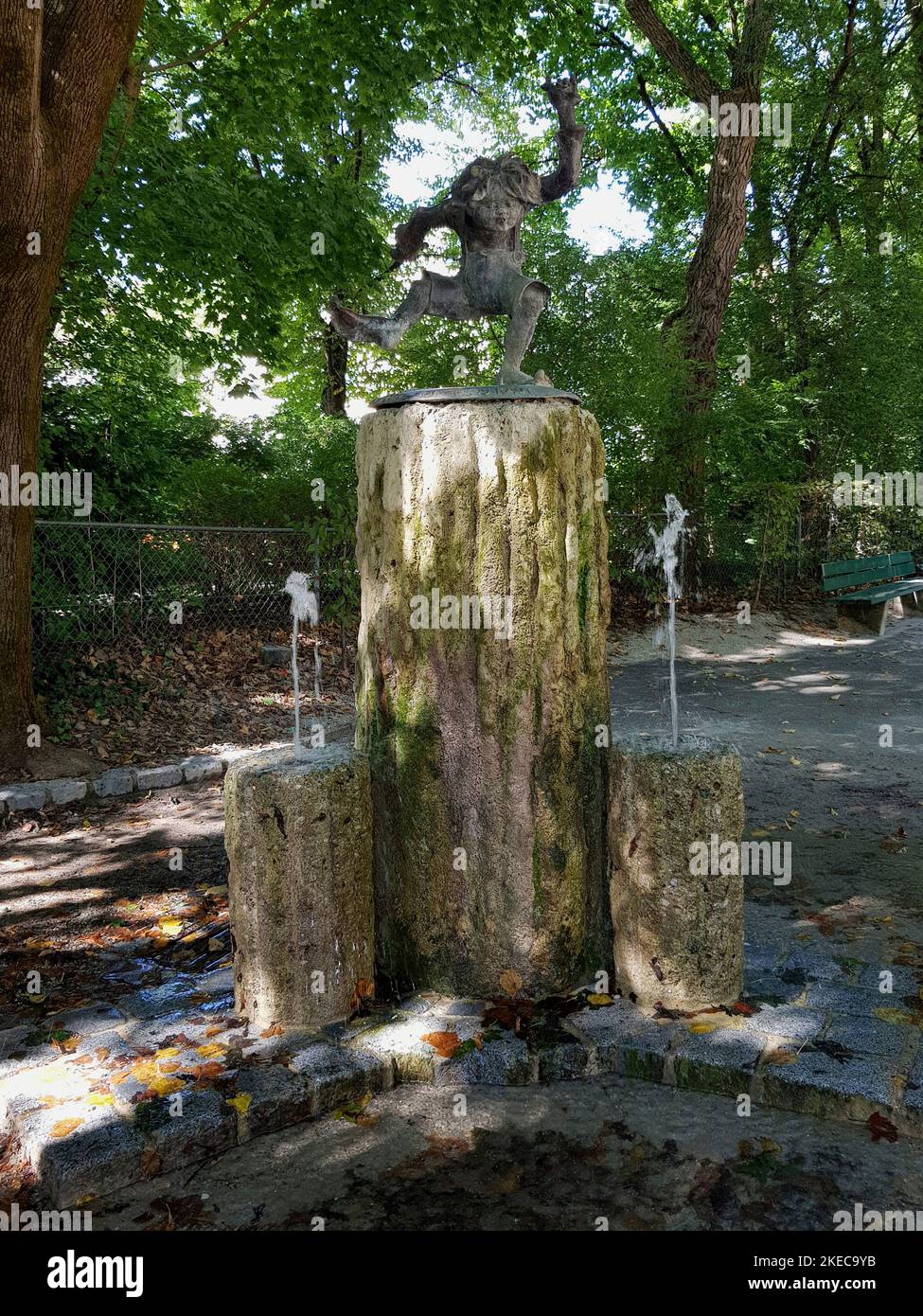 Fuente Pumuckl en Luitpoldpark, Schwabing. Pumuckl, conocido a través de la serie de televisión 'Meister Eder und sein Pumuckl', desde 1962 apareció la serie infantil de televisión de Elli Kaut. Se trata del infantil imp que juega muchos trucos en el Maestro Eder. En 1985, le fue erigido un monumento en forma de fuente. La escultura de bronce fue realizada por el escultor Claus Nageler. Foto de stock