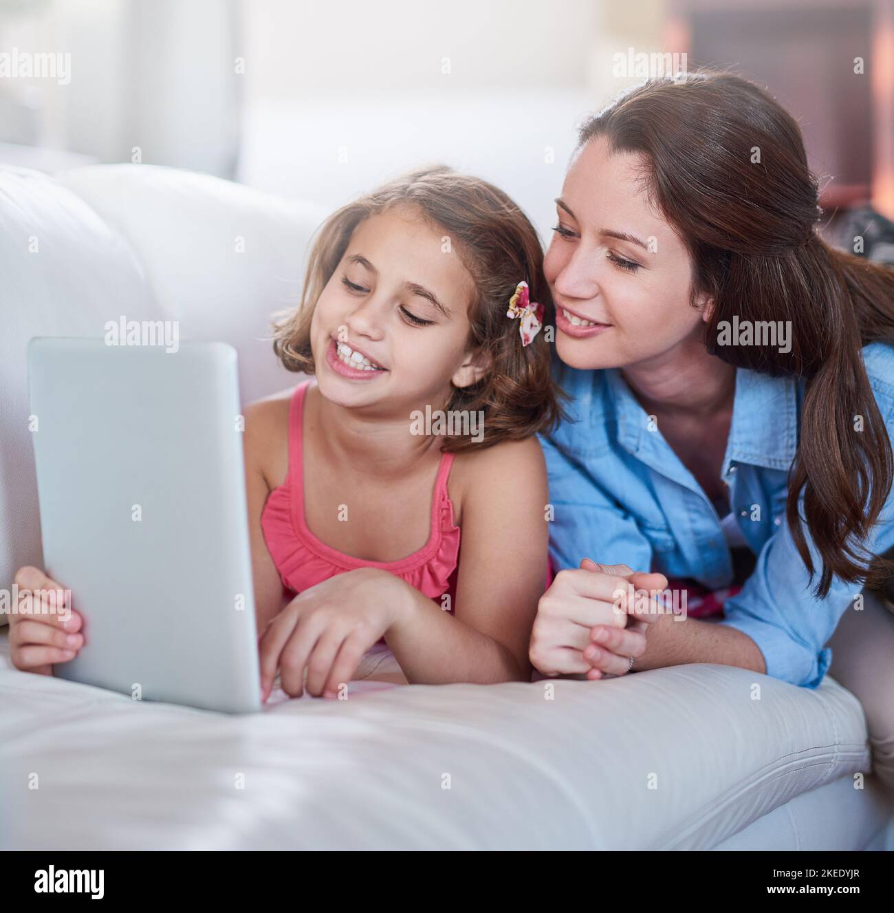 Storytime se vuelve digital. Una madre y su hija utilizan la tecnología inalámbrica en casa. Foto de stock