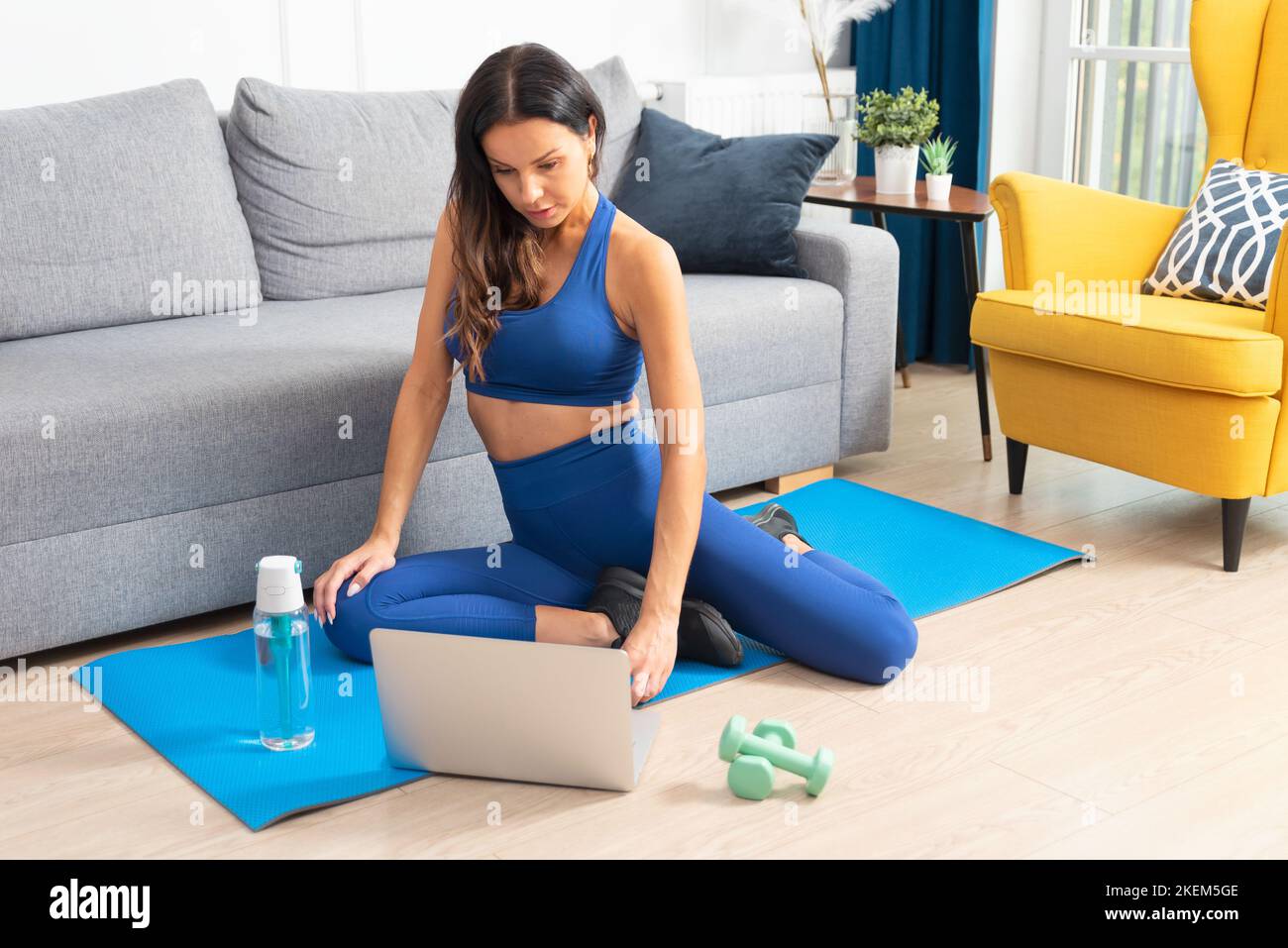 Mujer haciendo ejercicio en casa. Entrenamiento, concepto de ejercicio en casa con tutoriales en línea Foto de stock