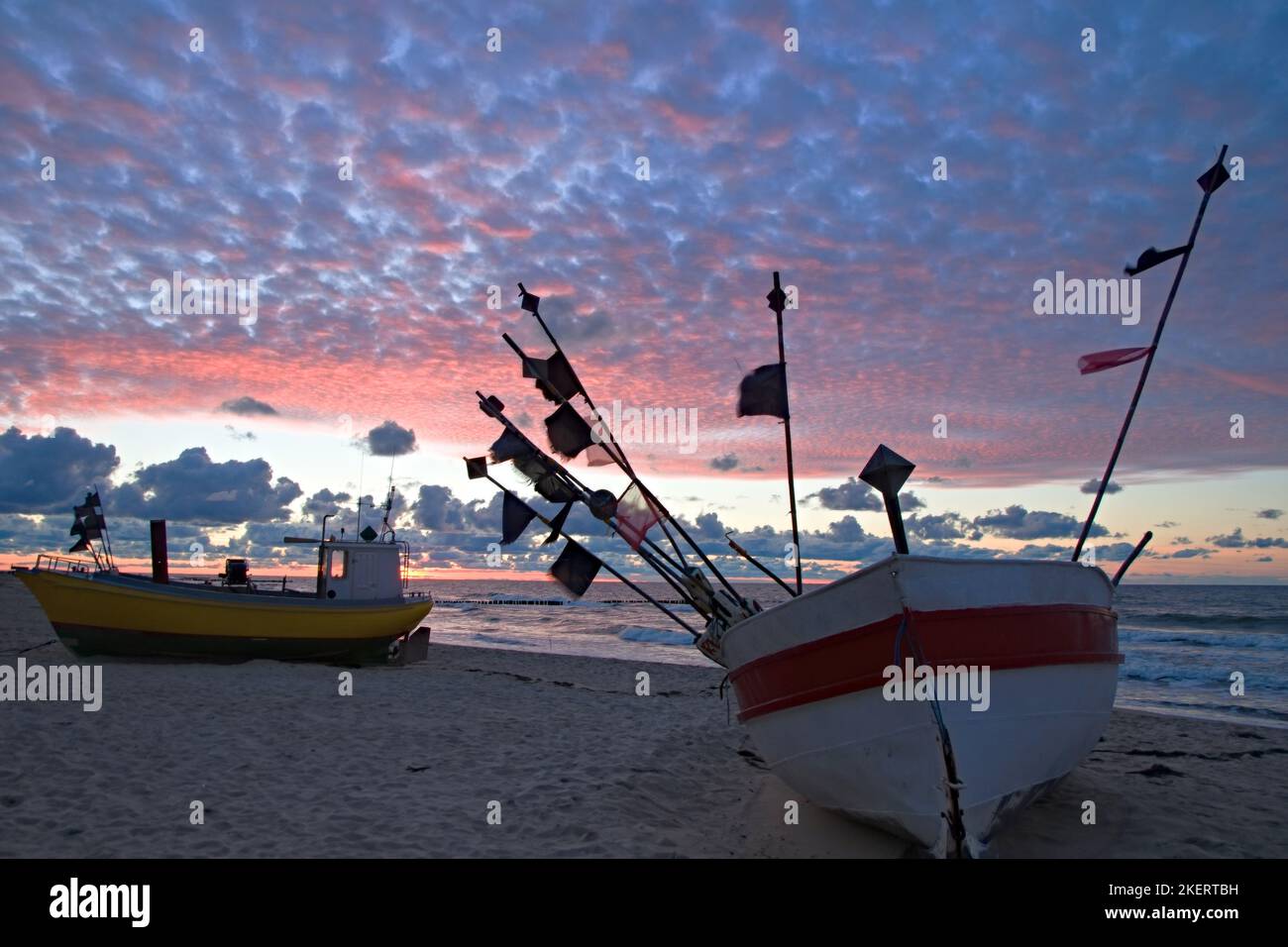 Barco de pesca en la playa de la costa polaca del Báltico cerca de Rewal. Puesta de sol Foto de stock
