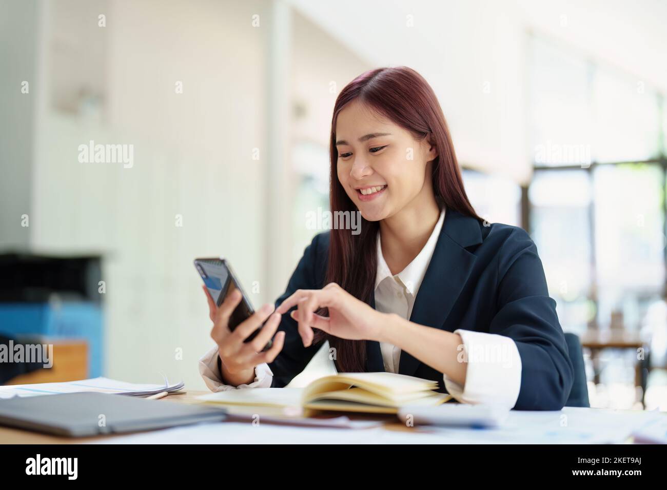 Mujer de negocios asiática que utiliza el teléfono para ponerse en contacto con un socio comercial Foto de stock