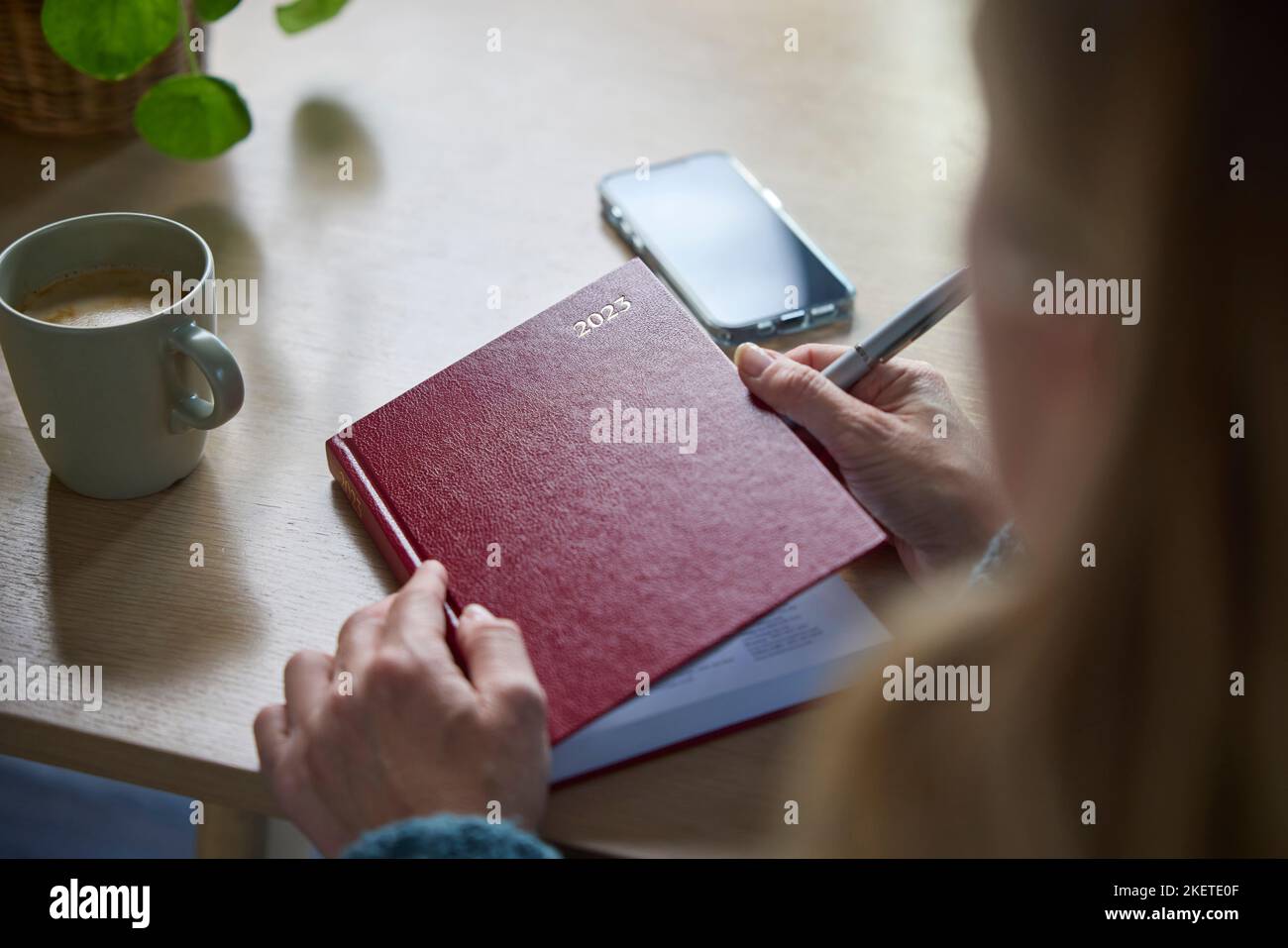 Close Up of Madure Woman Writing in New Year 2023 Diary at Home Foto de stock