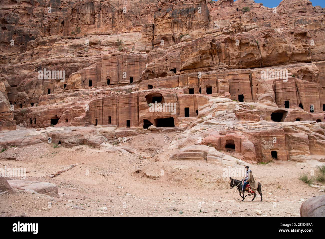 Hombre montando burro pasado Nabataean Petra tumbas Jordania Foto de stock