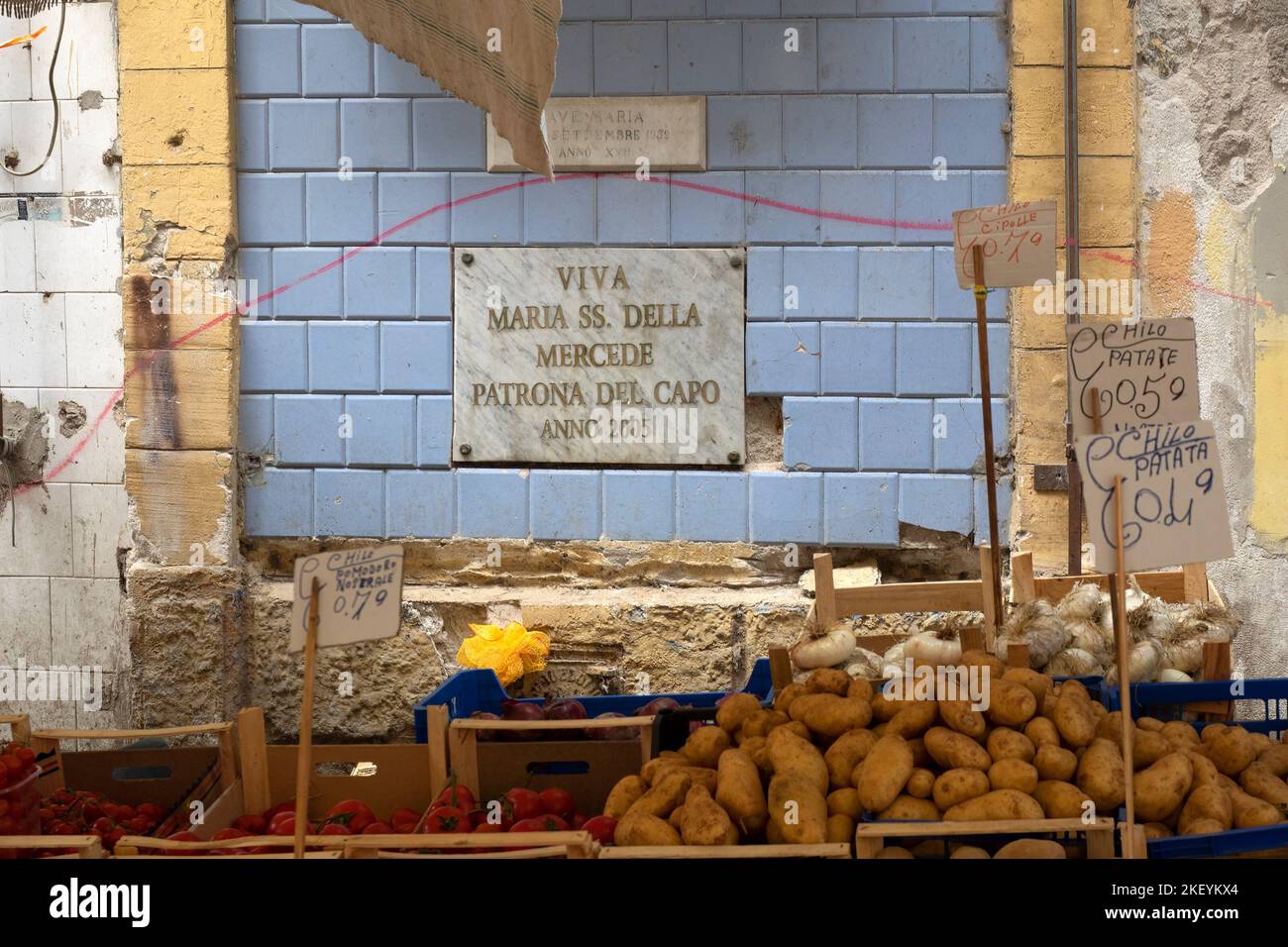 PALERMO, SICILIA, ITALIA - 21 DE MAYO de 2018: Pequeño establo de verduras en el mercado de La Vucciria con placa en honor a María Nuestra Señora de la Misericordia (Maria della Mercede) Foto de stock