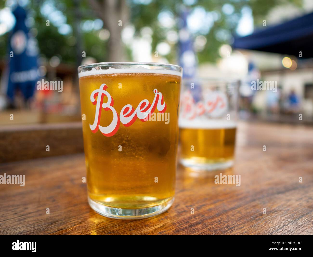 Primer plano de una pinta de cerveza lager sobre la mesa de un pub beer garden, Reino Unido Foto de stock