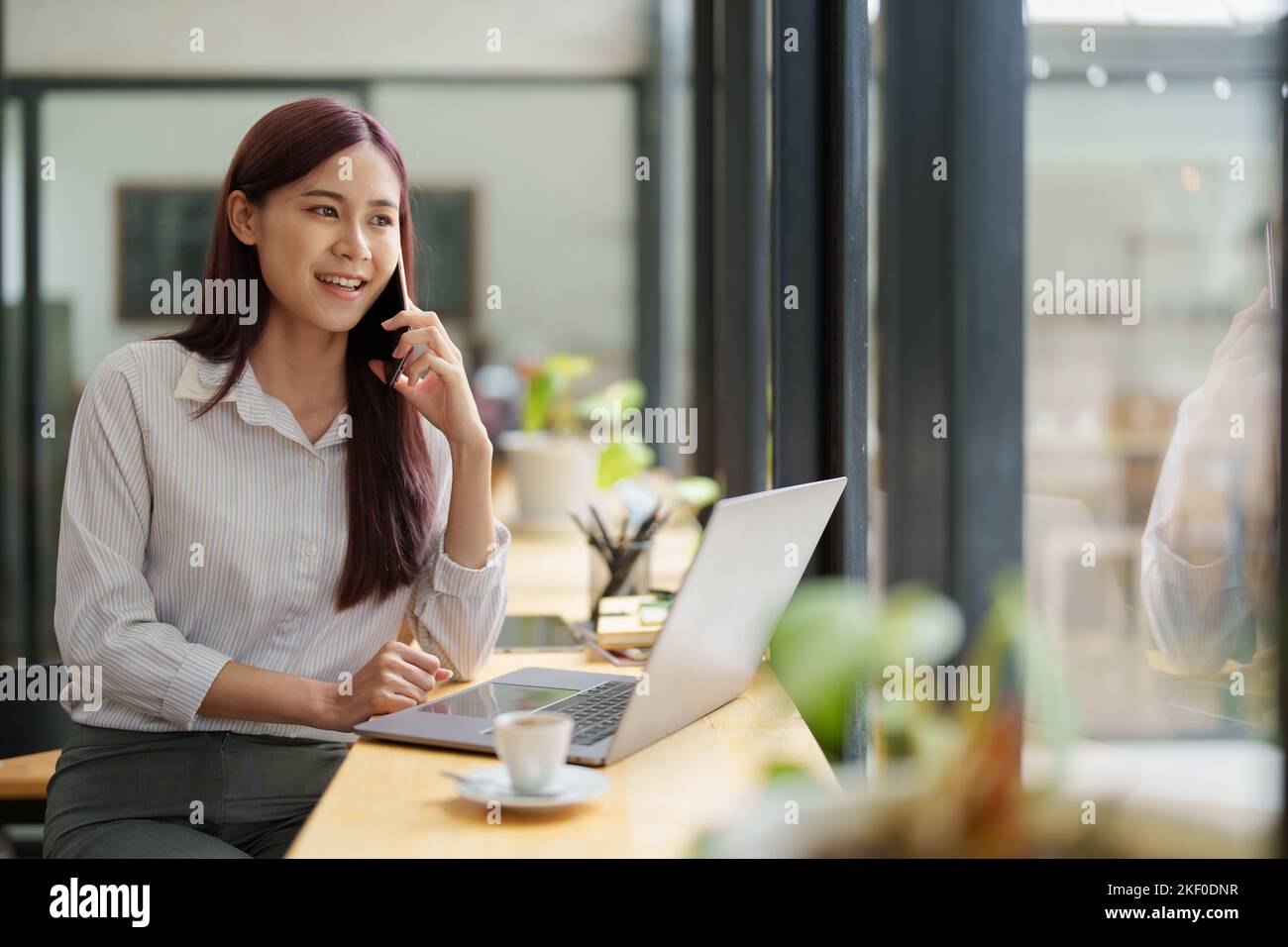 Mujer de negocios asiática que utiliza el teléfono para ponerse en contacto con un socio comercial Foto de stock