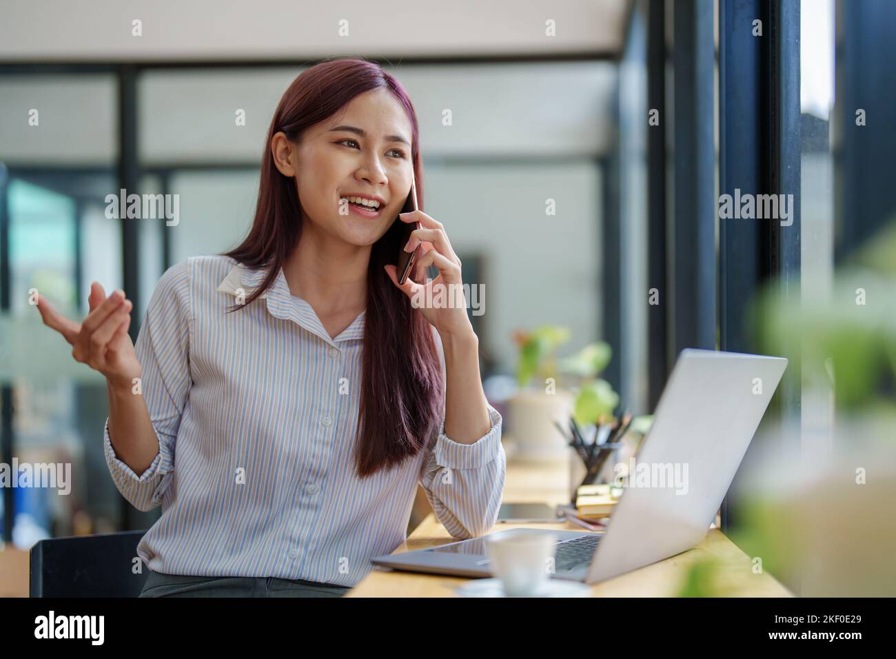 Mujer de negocios asiática que utiliza el teléfono para ponerse en contacto con un socio comercial Foto de stock