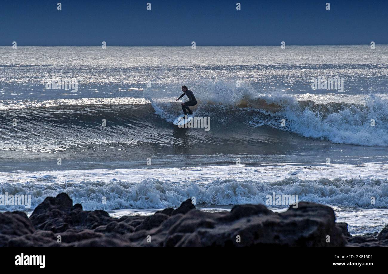 Swansea, Reino Unido. 15th de Nov de 2022. Un surfista montando las olas en la bahía de Langland, Swansea esta tarde durante un descanso en el tiempo húmedo. Crédito: Phil Rees/Alamy Live News Foto de stock