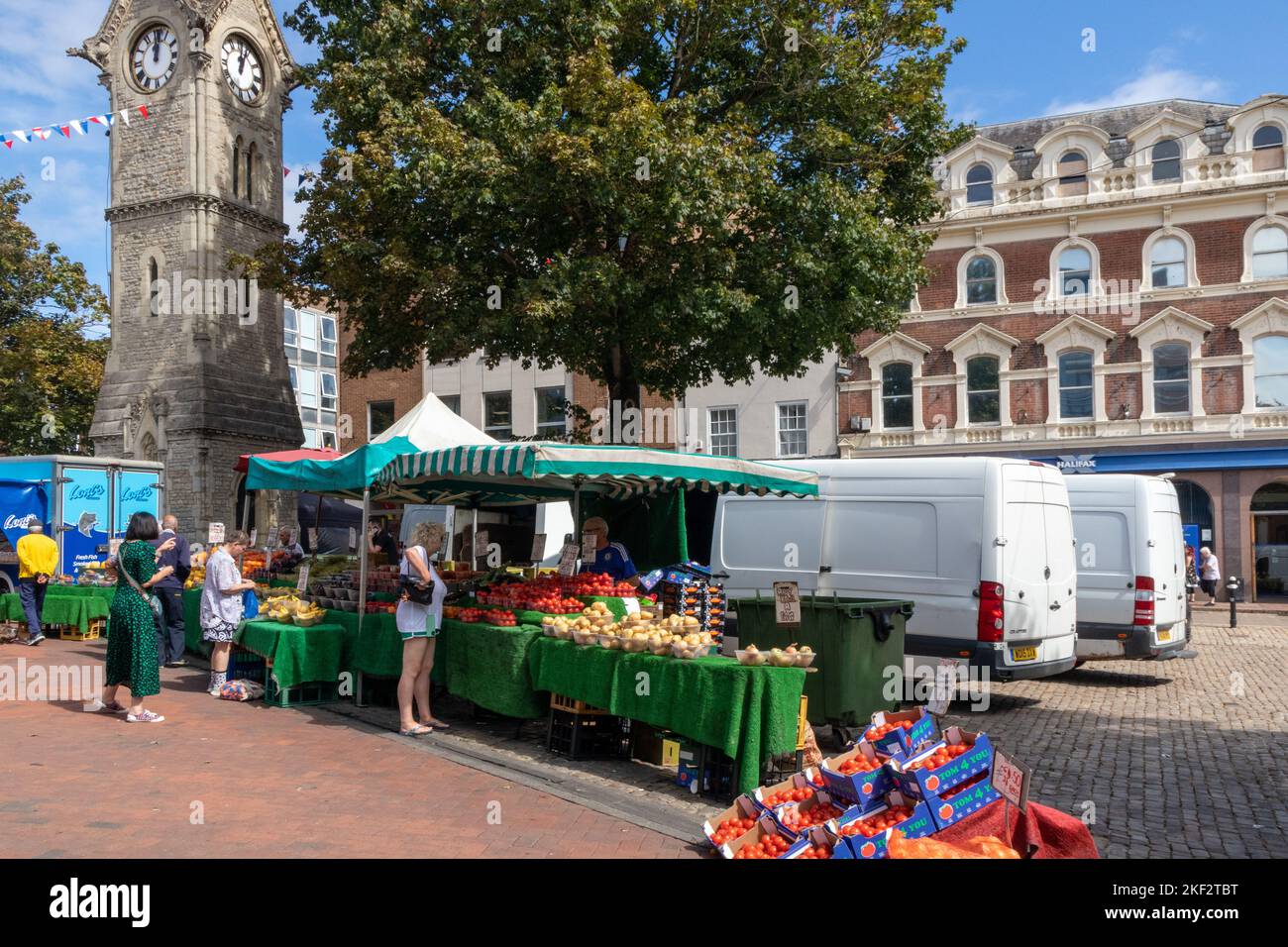 Torre del reloj y puesto de frutas y verduras, la plaza del mercado, Aylesbury, Buckinghamshire, Inglaterra Foto de stock