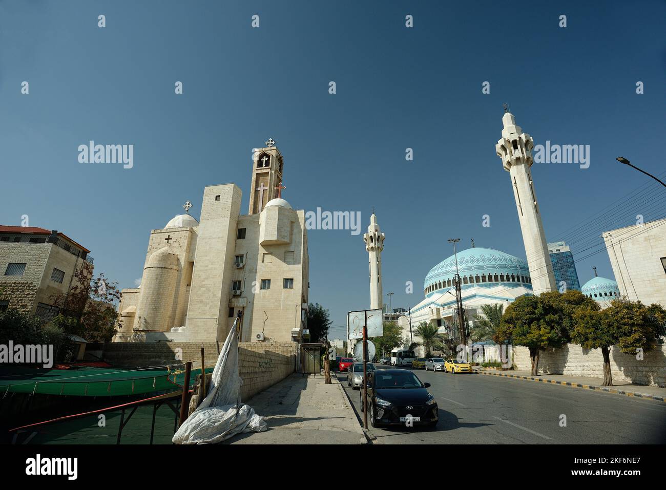 Una iglesia cristiana y una mezquita islámica moderna una al lado de la otra en Ammán, Jordania. Tanto la iglesia contemporánea como la arquitectura islámica. Foto de stock