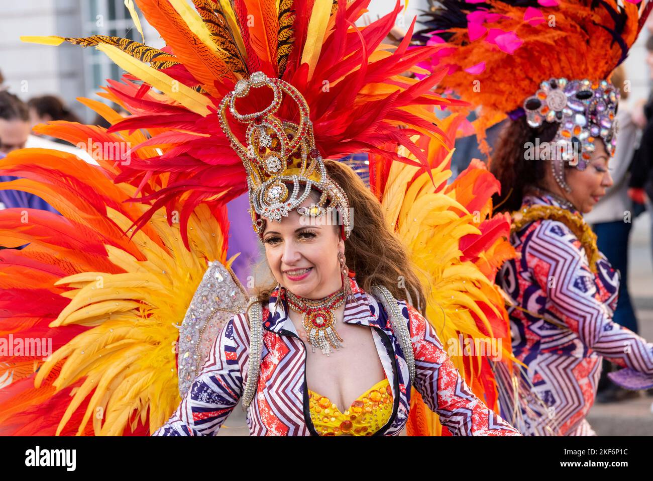 Mujer en traje de carnaval de plumas de pavo real bailando en show