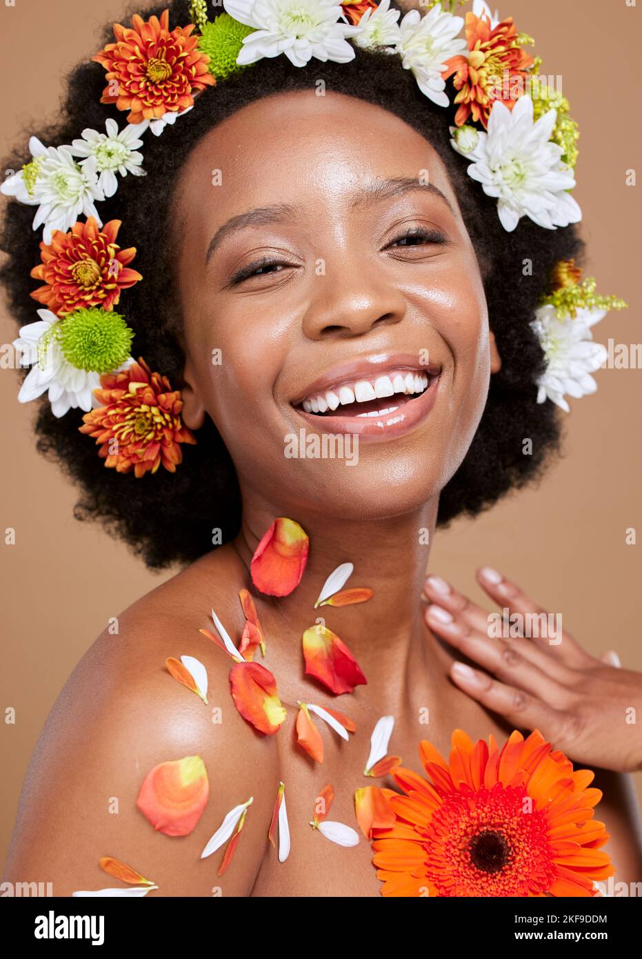 Corona de flores, belleza y retrato de mujer negra con sonrisa sobre fondo marrón en estudio. Cuidado del cabello, cosméticos y chica feliz modelo para natural Foto de stock
