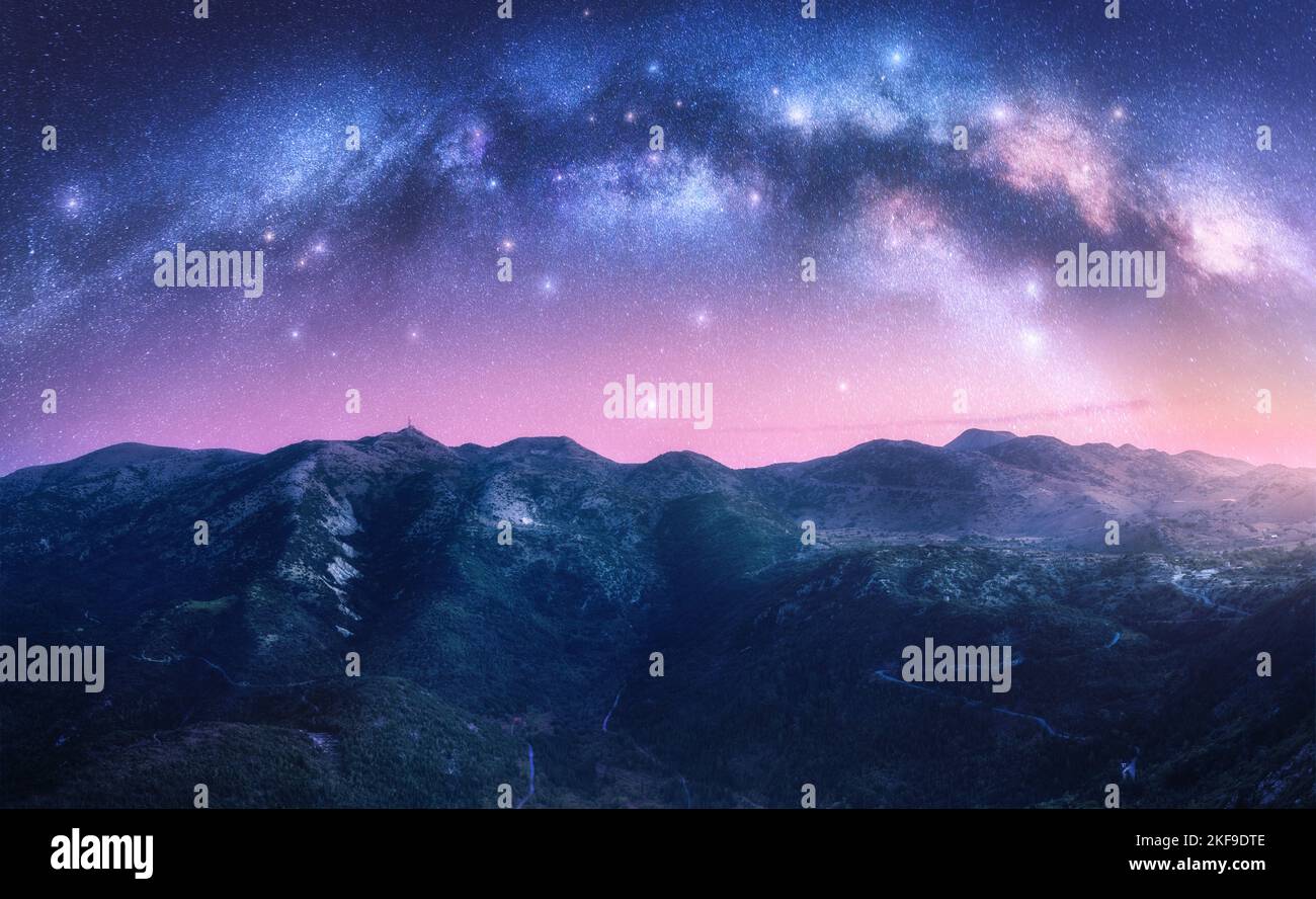Arco de Vía Láctea sobre las montañas en la noche estrellada Foto de stock