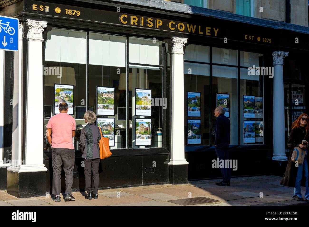 Gente mirando en la ventana de una oficina de agentes inmobiliarios en Bath, Somerset, Inglaterra, Reino Unido Foto de stock